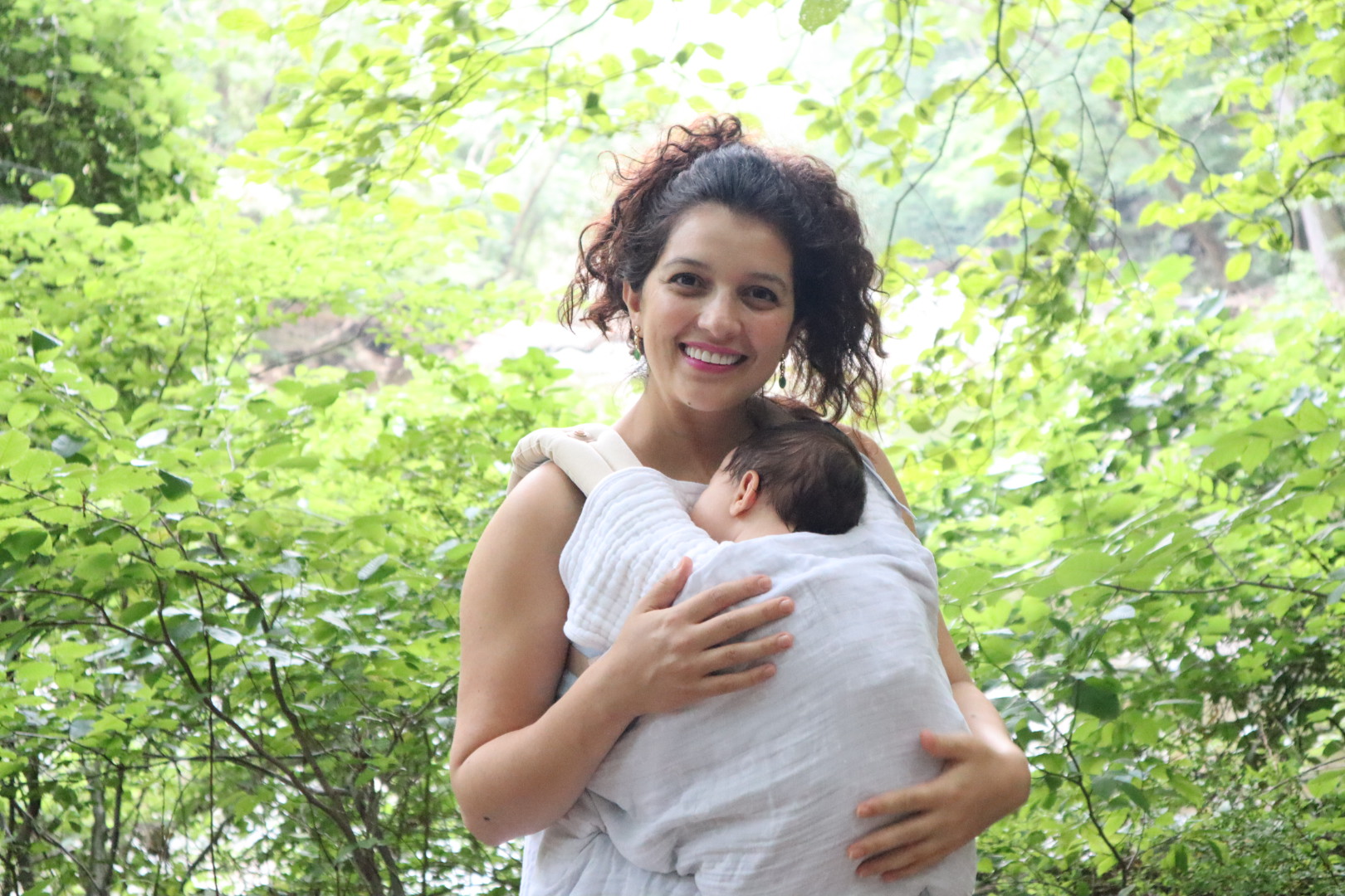 Saloua holding her newborn daughter Muna in the forest